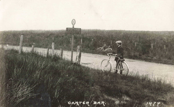 Old real photo postcard of a gentleman with his bicycle at Carter Bar