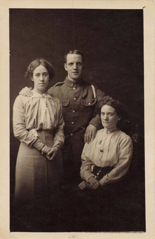 Old real photo postcard of a soldier with two ladies - mother and wife perhaps