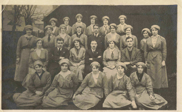 Old real photo postcard of what is possibly a group of female factory workers with male bosses